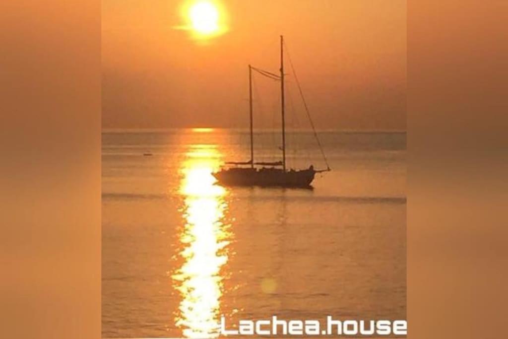 ein Boot im Wasser mit Sonnenuntergang im Hintergrund in der Unterkunft Lachea House appartamento sul mare dei Ciclopi in Aci Castello