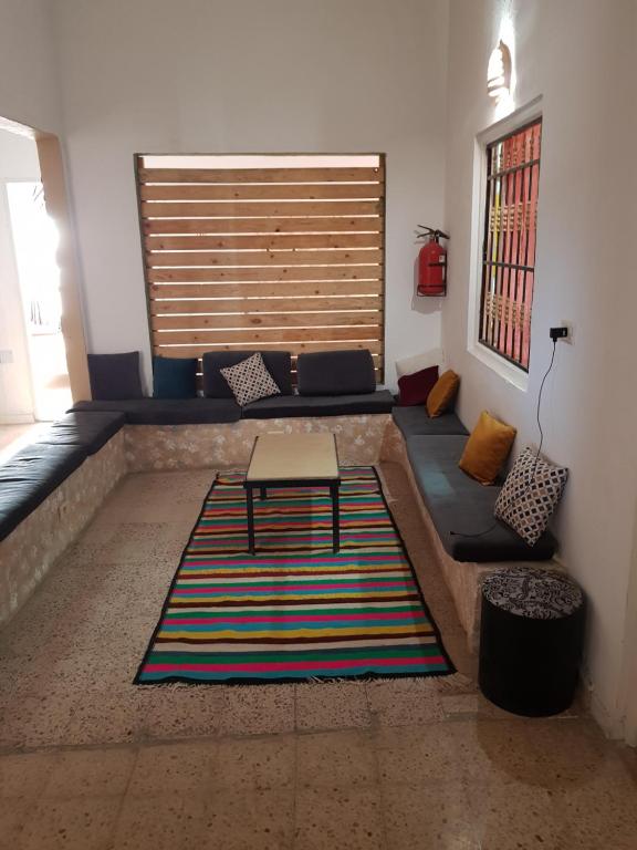 sala de estar con sofá y mesa sobre una alfombra en Auberge Alferdaous, en Tataouine