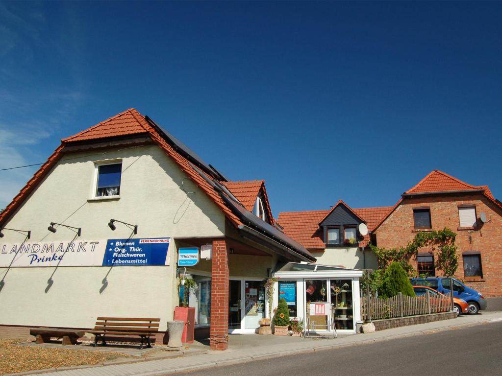 ein Gebäude mit einer Bank vor einem Geschäft in der Unterkunft Ferienwohnung Prinke in Niedertrebra