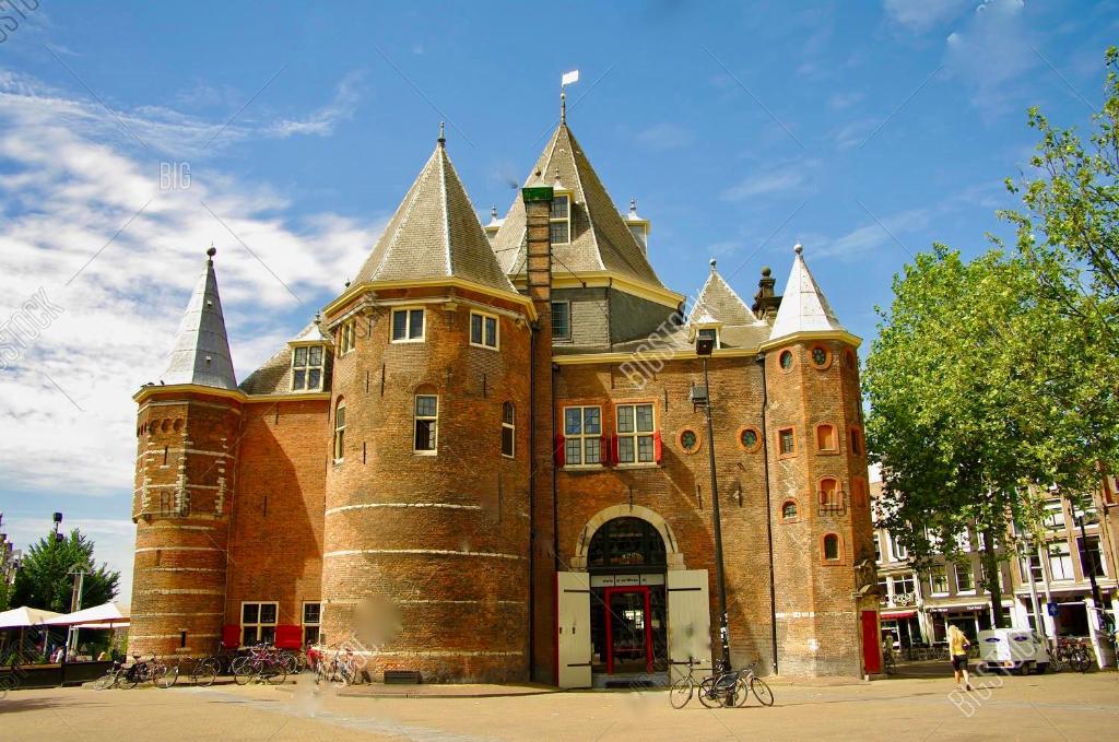 a large brick building with towers on top of it at St Antonis Apartment in Amsterdam