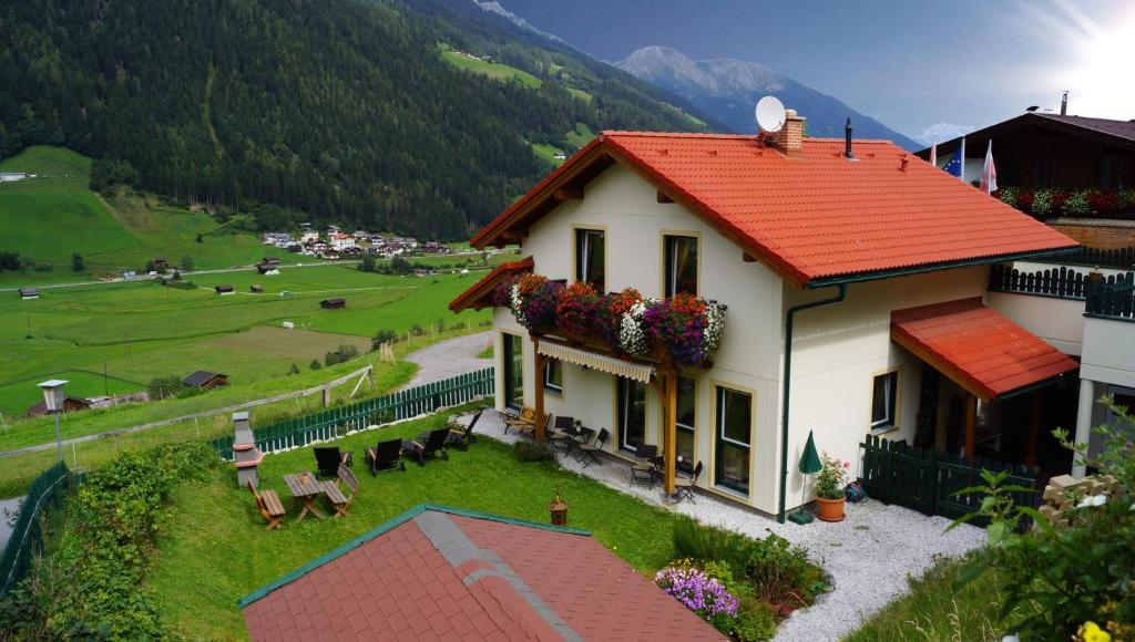 a white house with a red roof and a field at Chalet Olympia in Neustift im Stubaital