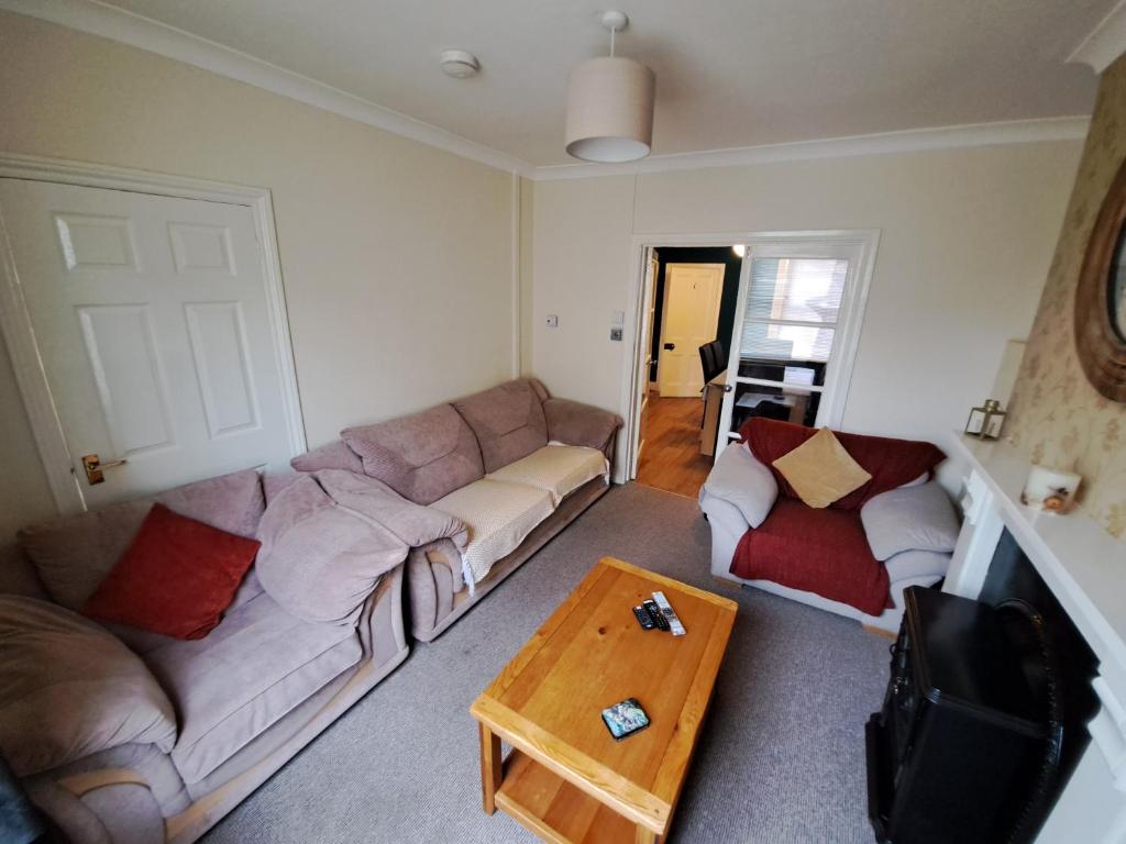 a living room with a couch and a coffee table at Entire town house with free parking in Oswestry