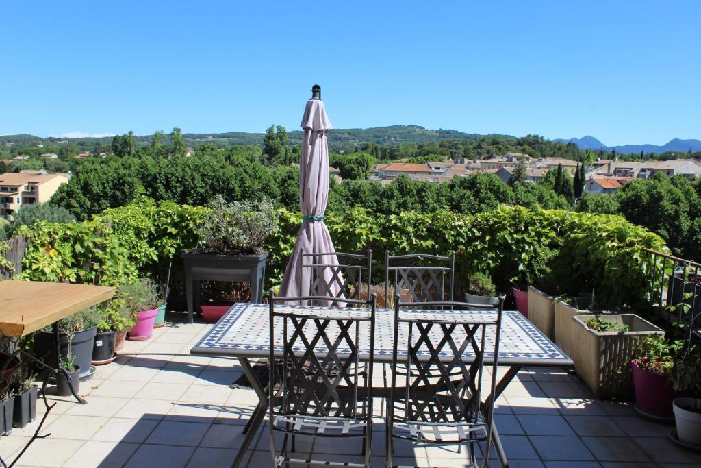un patio avec une table et un parasol dans l'établissement Maison de ville historique dans la Haute Ville -, à Vaison-la-Romaine
