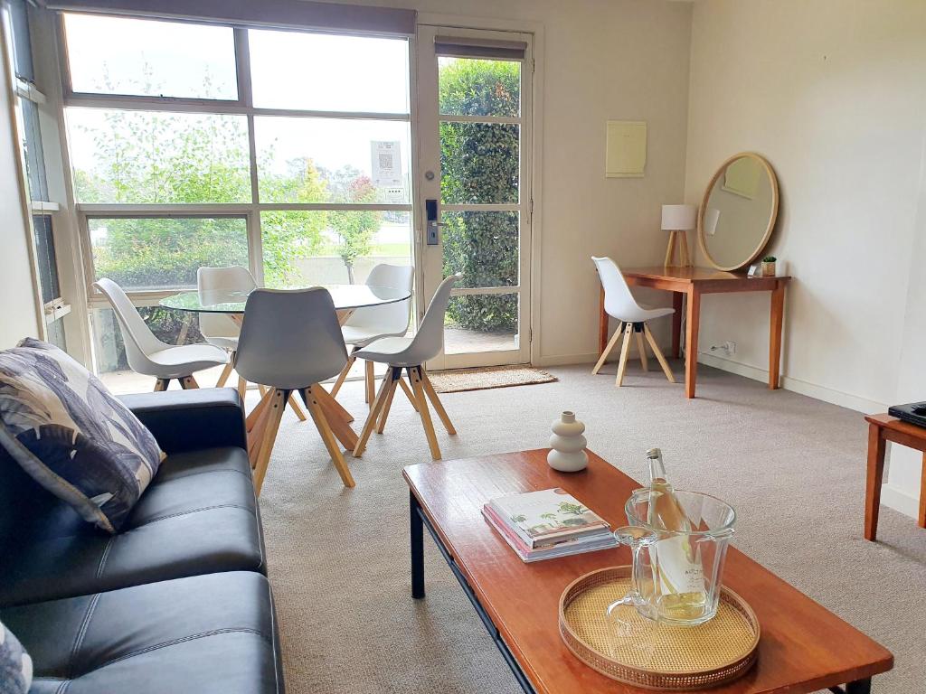 een woonkamer met een bank en een tafel bij Central Shepparton Apartments in Shepparton