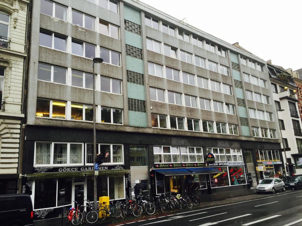 un gran edificio con bicicletas estacionadas frente a él en Hotel Garni Emir, en Colonia