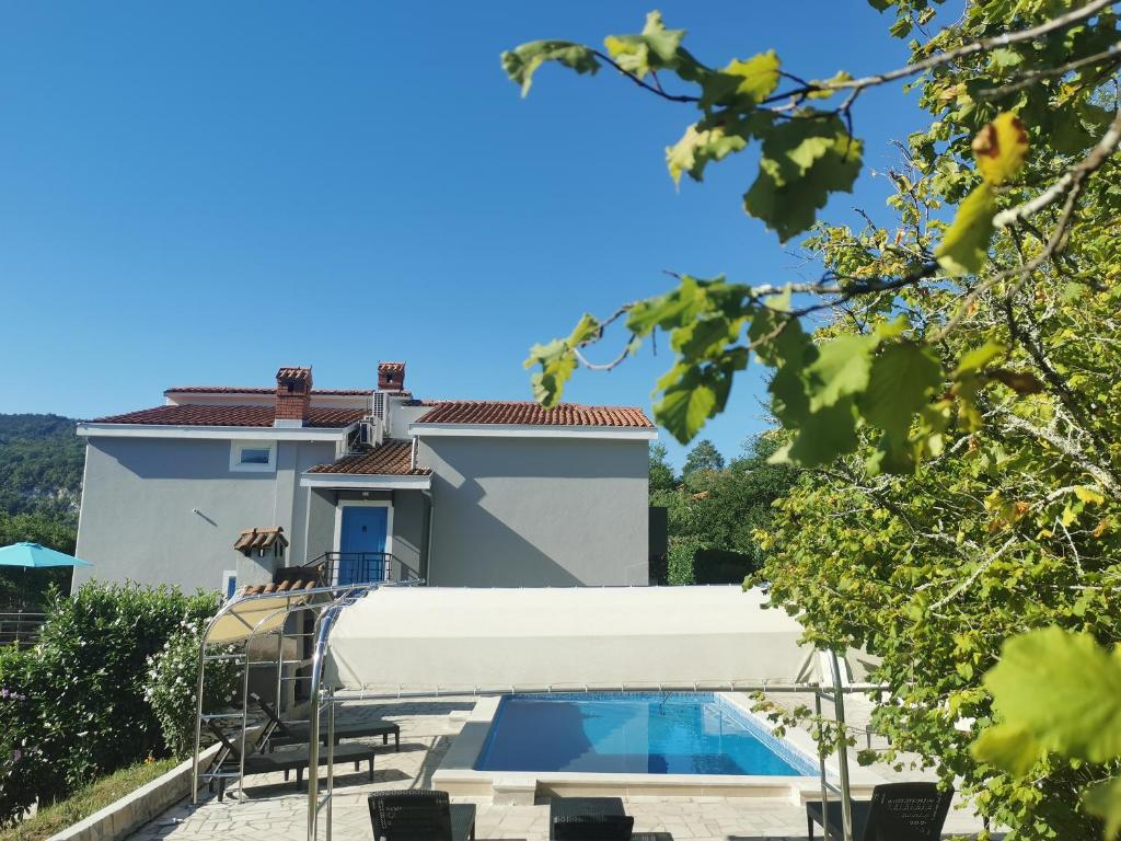 een villa met een zwembad en een huis bij Holiday Home Mandalena in Buzet