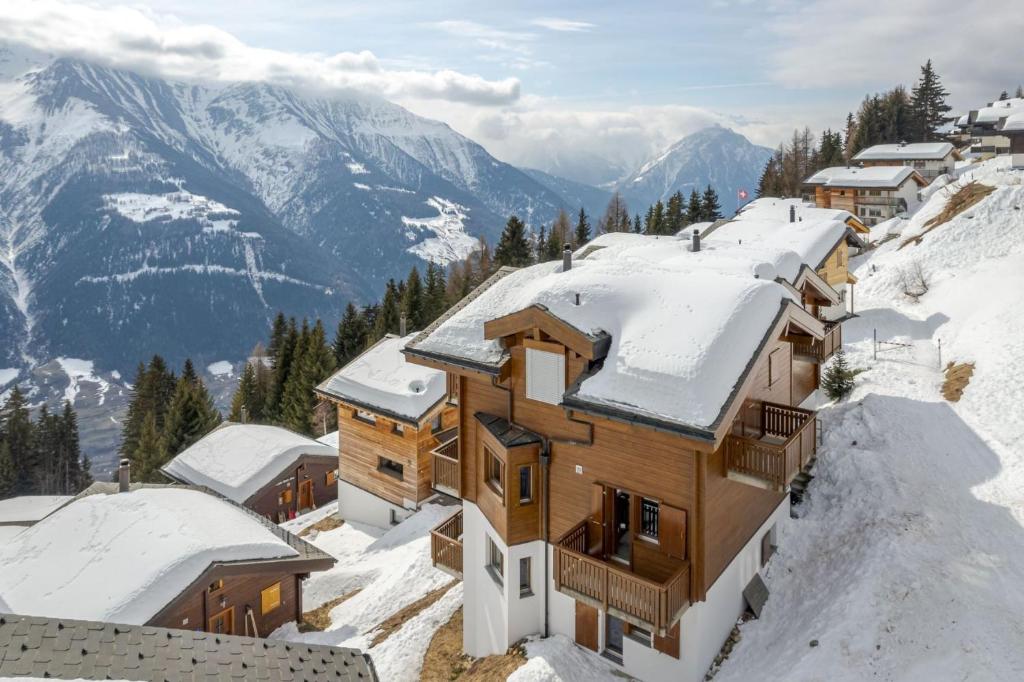 a row of wooden houses in the snow at Camelot 3 in Bettmeralp