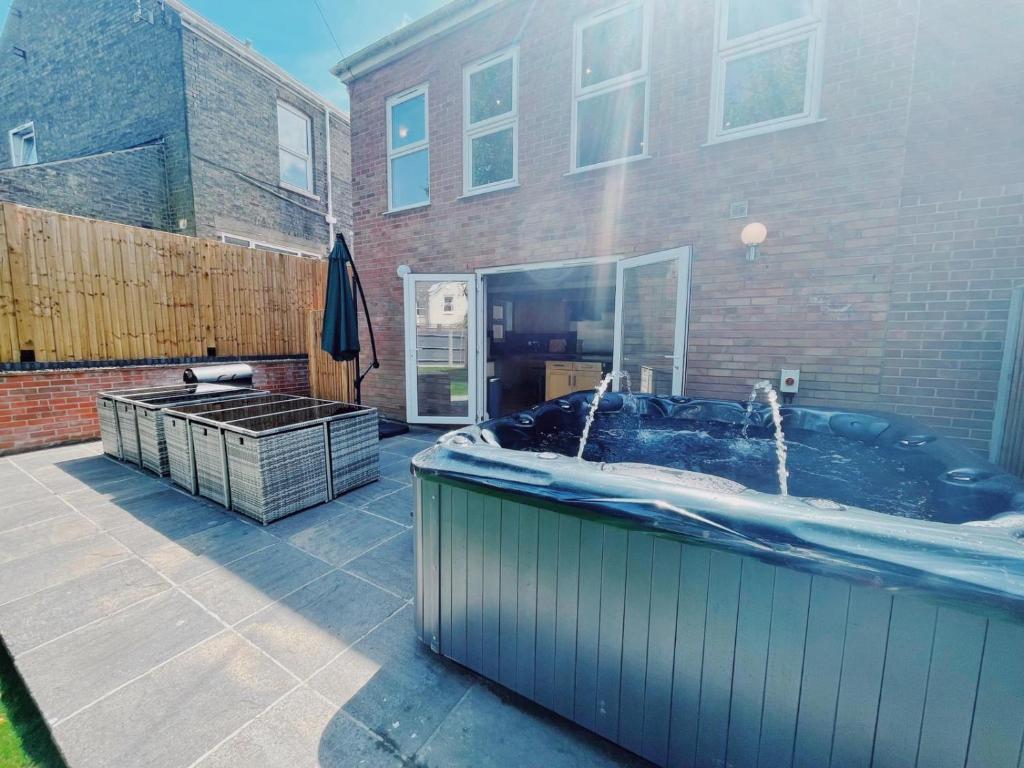 a hot tub in a yard next to a building at Stunning 8-Bed House with Sea & Beach Views in Great Yarmouth