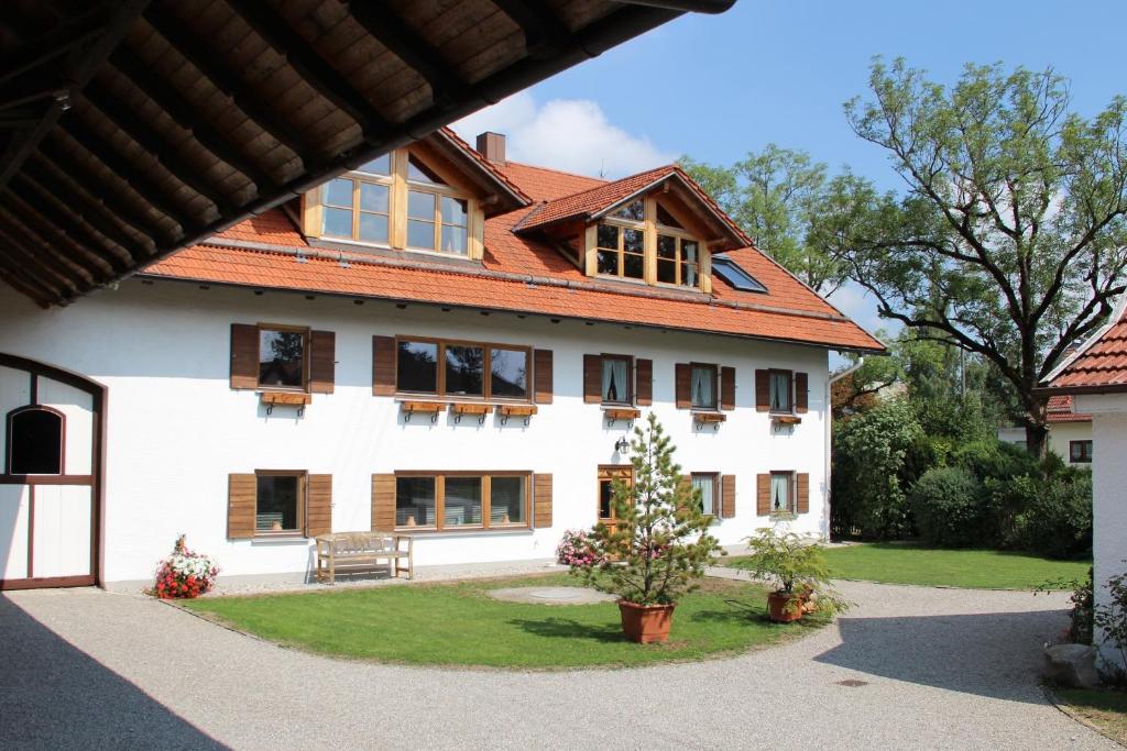 ein großes weißes Haus mit rotem Dach in der Unterkunft Michlhof in Oberostendorf