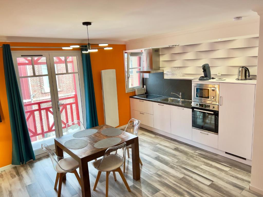 Una cocina con una mesa y sillas en una habitación. en Plage à 50m Appartement Rêves ensoleillés Villa Les Bains de Mers, en Mers-les-Bains