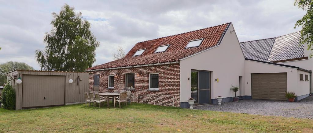 una casa de ladrillo con una mesa en el patio en Vakantiewoning Tilia en Zottegem