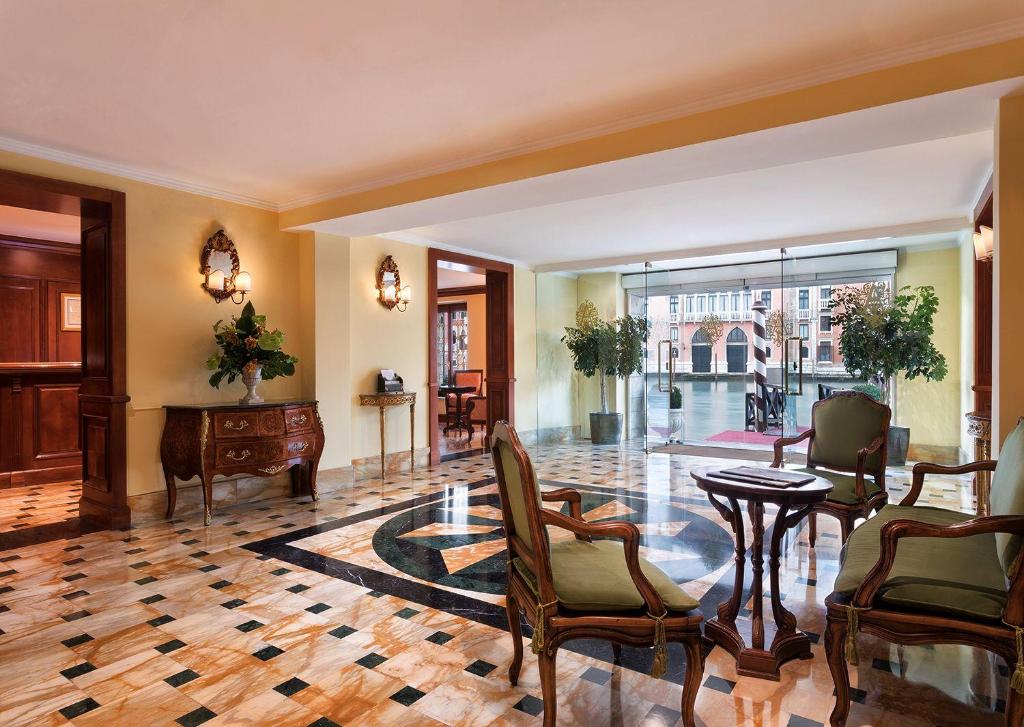 a lobby with a table and chairs and a desk at Sina Palazzo Sant'Angelo in Venice