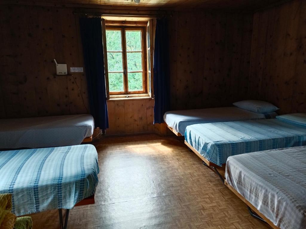 a room with three beds and a window at Guesthouse Seghetto in Valdidentro