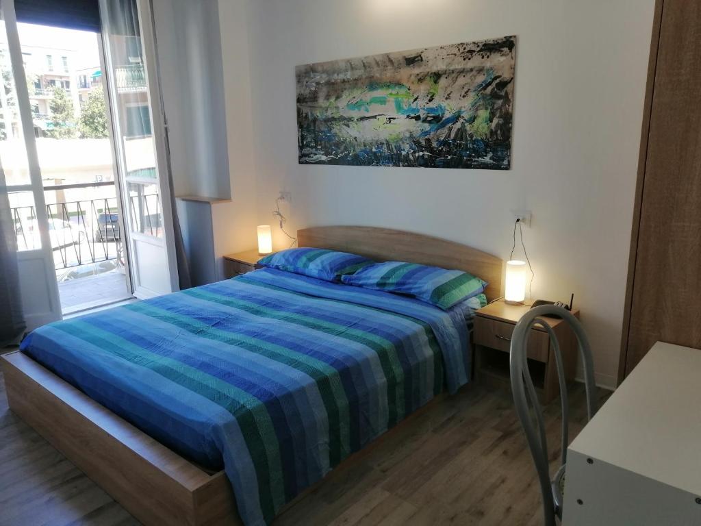 a bedroom with a bed and a painting on the wall at Albergo blue fish in Albisola Superiore