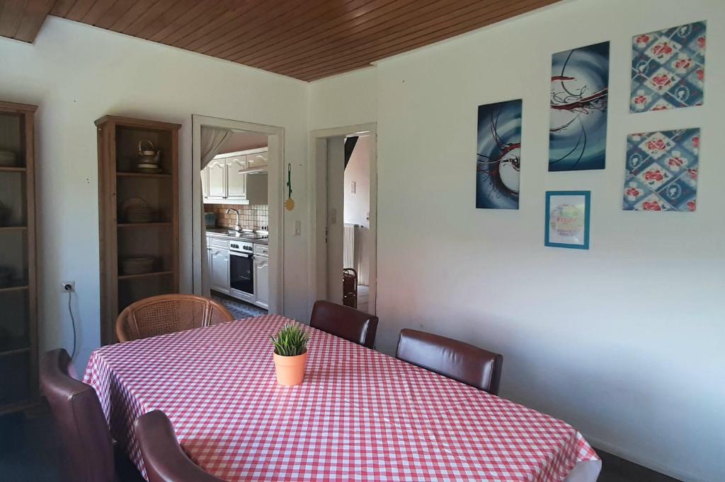 a dining room table with a red and white checkered table cloth at Monteurzimmer Ausma Wymeer Bunde - FeWo Vakantiehuis Heerenland in Bunde