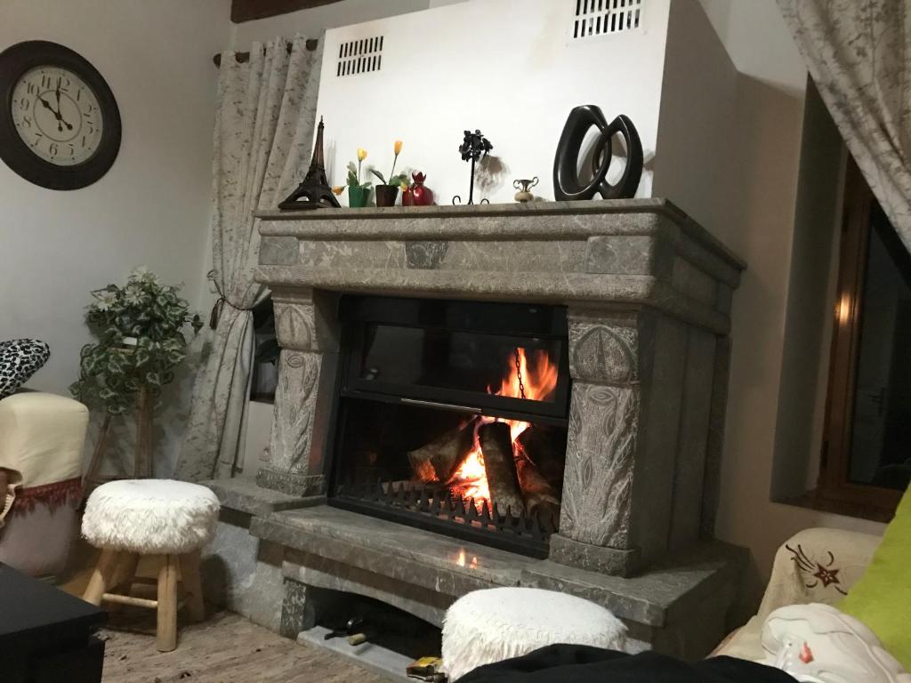 a fireplace in a living room with a fire at Vila Korchari Dardhe in Korçë