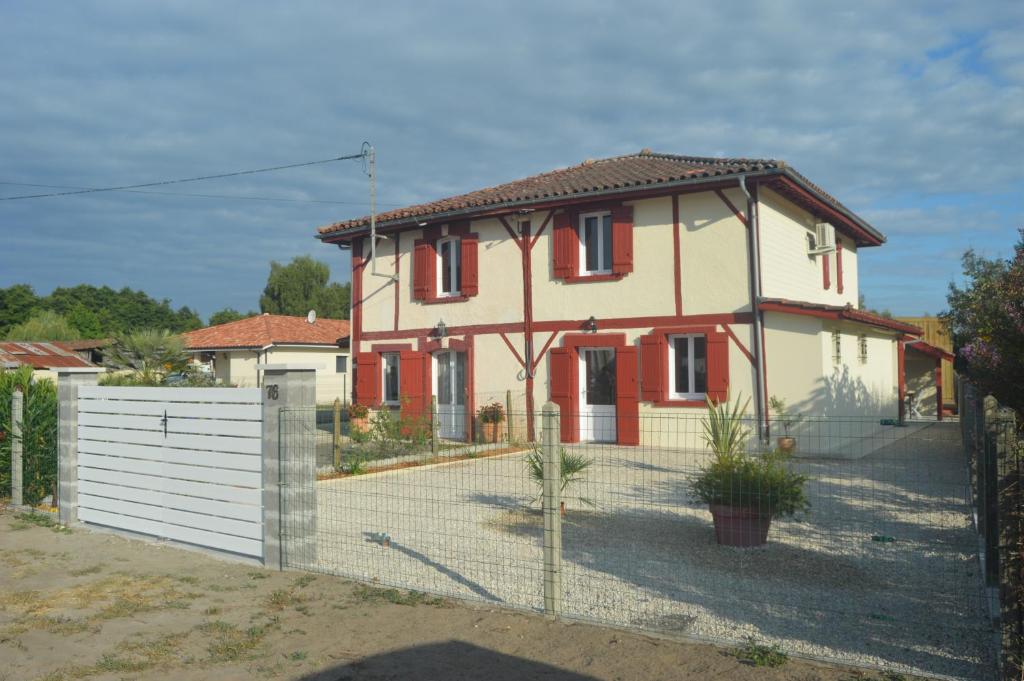une maison avec une clôture devant dans l'établissement Maison landaise rénovée avec charme, à Lit-et-Mixe