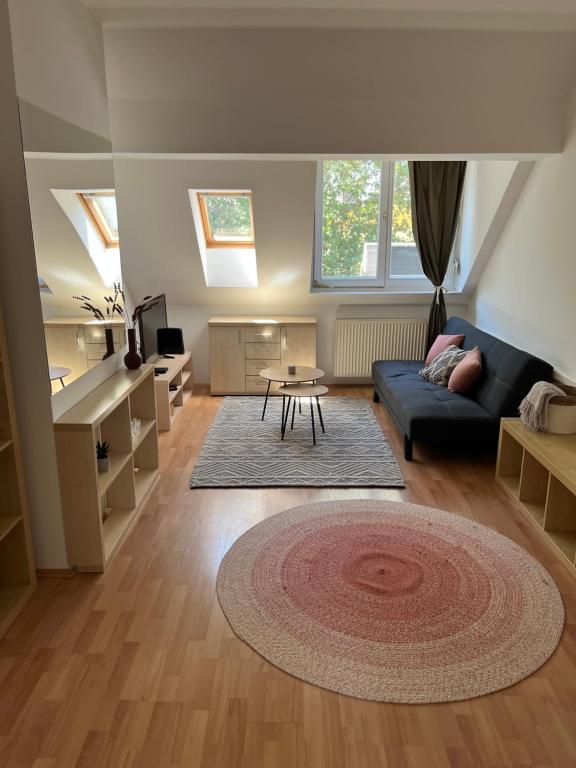 a living room with a blue couch and a table at Studio Loft in Pécs