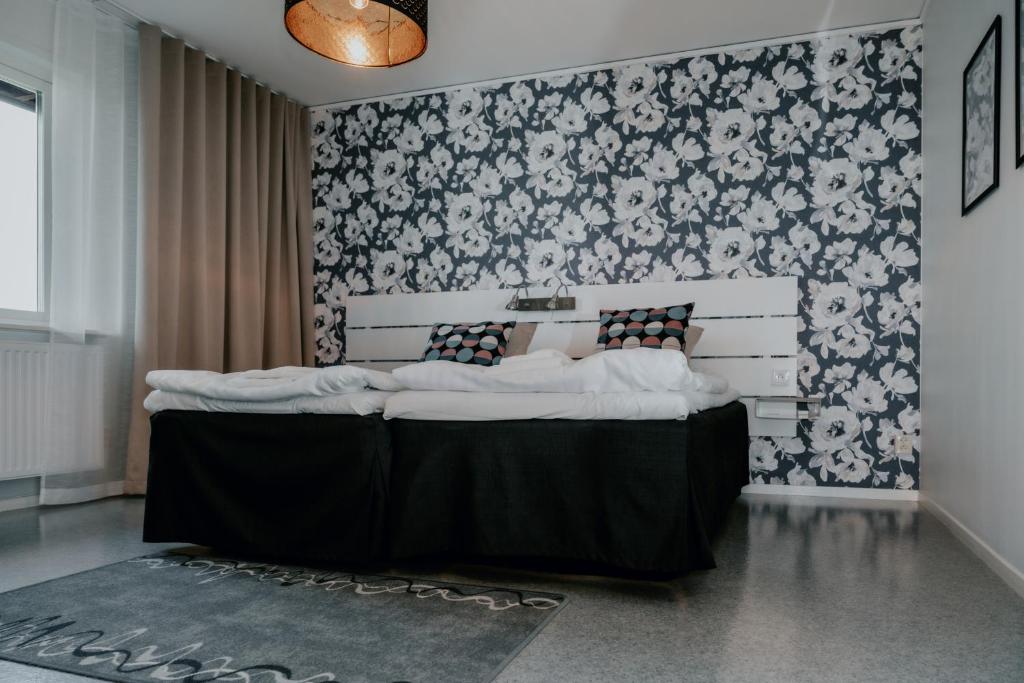 - une chambre avec un lit orné d'un mur fleuri dans l'établissement Wisingsö Hotell, à Visingsö