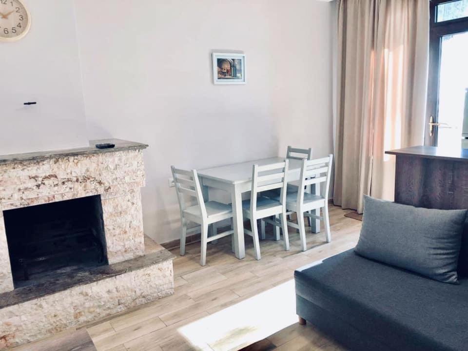 sala de estar con chimenea, mesa y sillas en Fortuna Cottage Bakuriani en Bakuriani