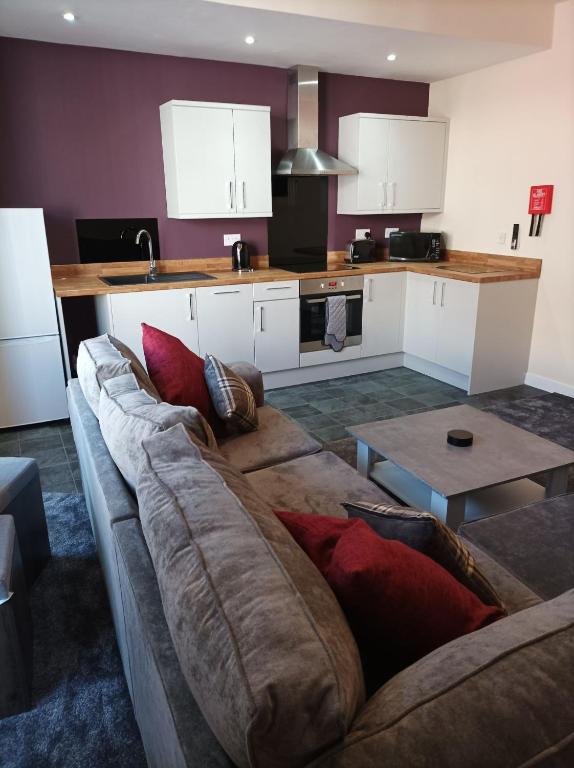 a living room with a couch and a kitchen at Rose James Apartments in Blackpool