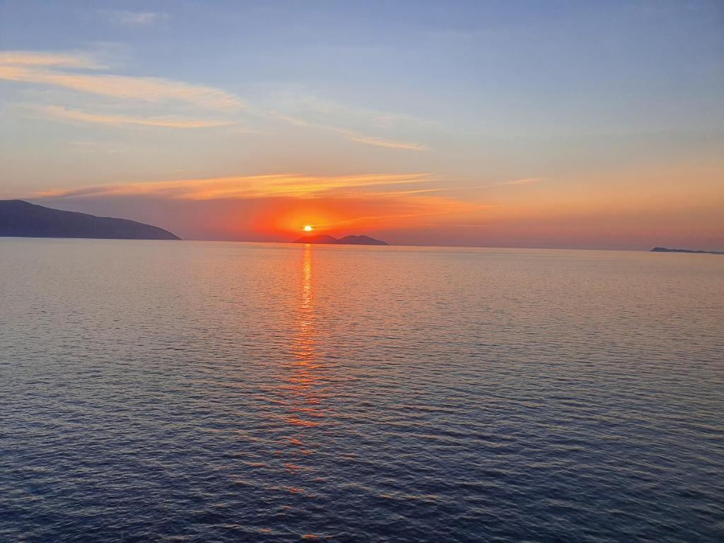 un coucher de soleil sur une grande étendue d'eau dans l'établissement Darla Sea View Apartment, à Vlorë