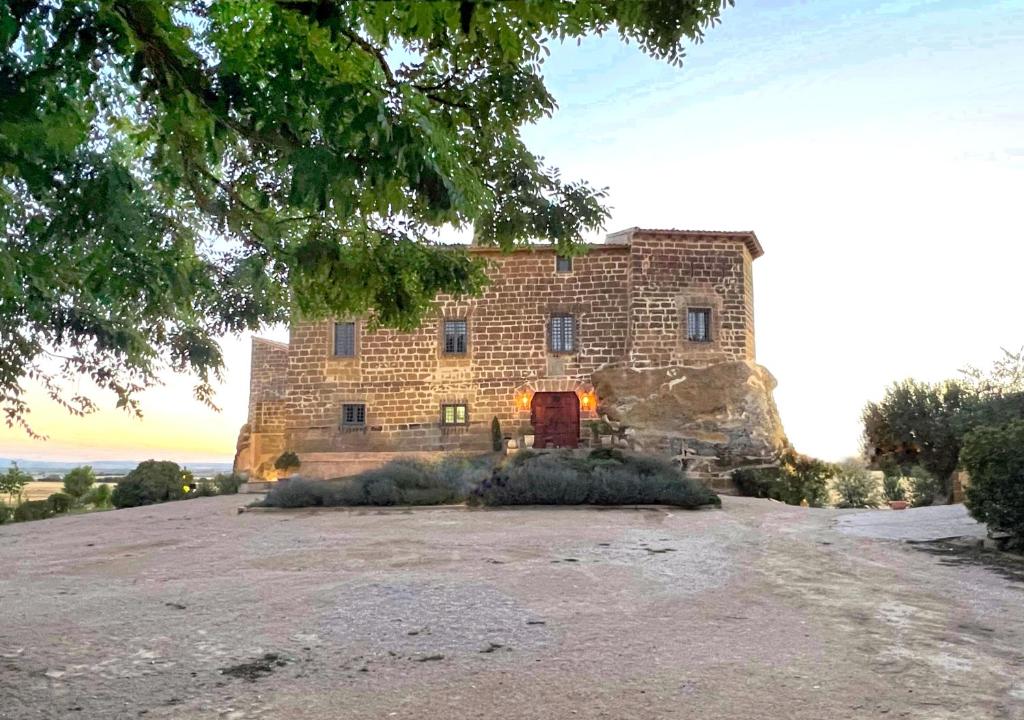 um grande edifício de tijolos no topo de uma colina em Castillo de Corvinos em Huesca