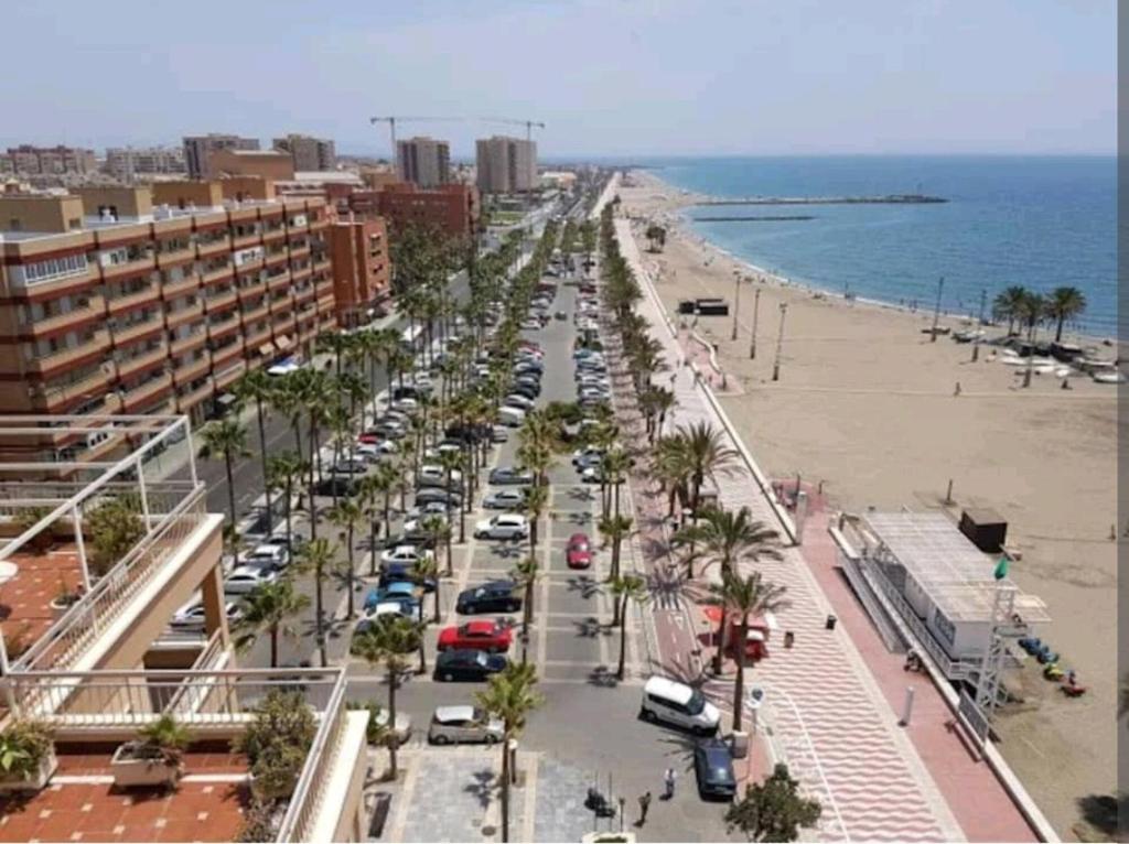 APARTAMENTO ZAPILLO ALMERIA 100 METROS DE LA PLAYA في ألميريا: شارع فيه سيارات تقف على الشاطئ