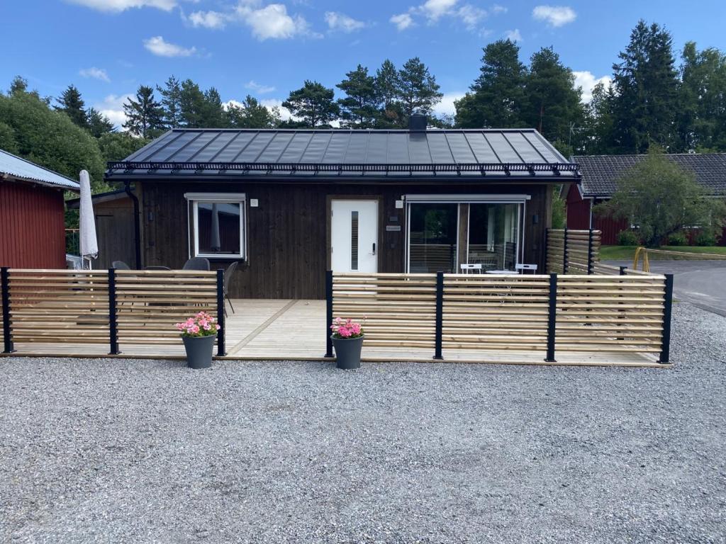 a small cabin with a solar roof on a gravel driveway at Ekberg Annexet in Järvsö