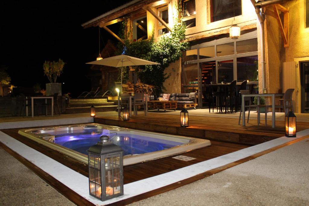 a swimming pool with lights and a patio at night at Lili Paradis in Saint-Savin