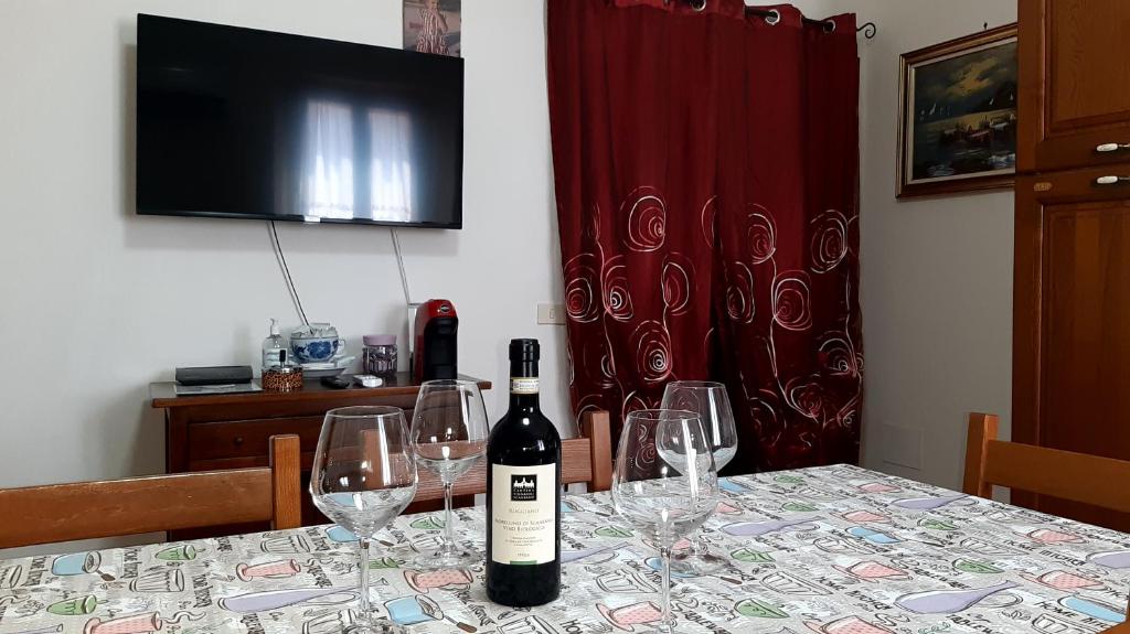 una botella de vino sentada en una mesa con copas en Agriturismo Uliveto Gretacci, en Montemerano