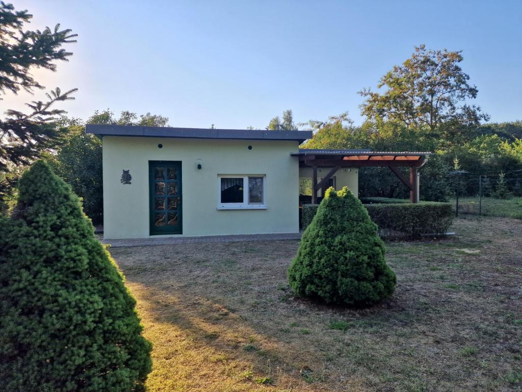 una casa con dos árboles delante de ella en Bungalow in Canow, en Wustrow