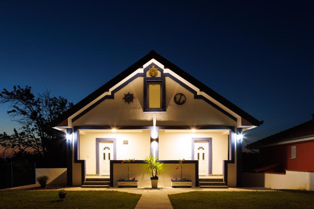 una casa blanca con luces encendidas por la noche en Vila Peristeron, en Golubac