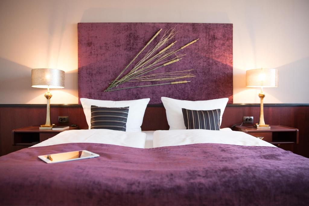 Hotel Kristall في فايسفاسر: غرفة نوم بسرير ارجواني مع مصباحين