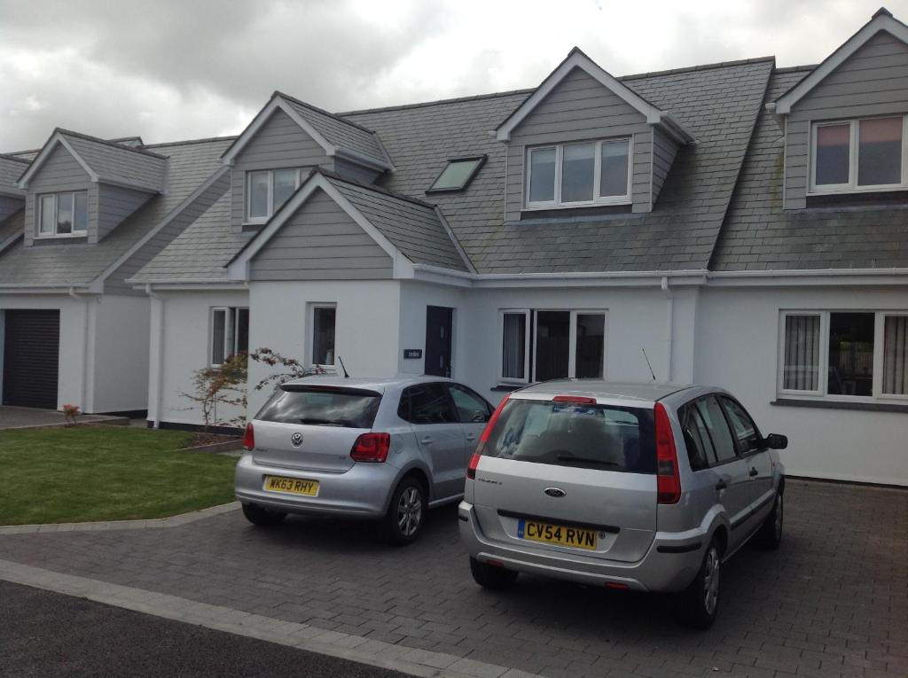 zwei Autos auf einem Parkplatz vor einem Haus geparkt in der Unterkunft Hedlea in Redruth