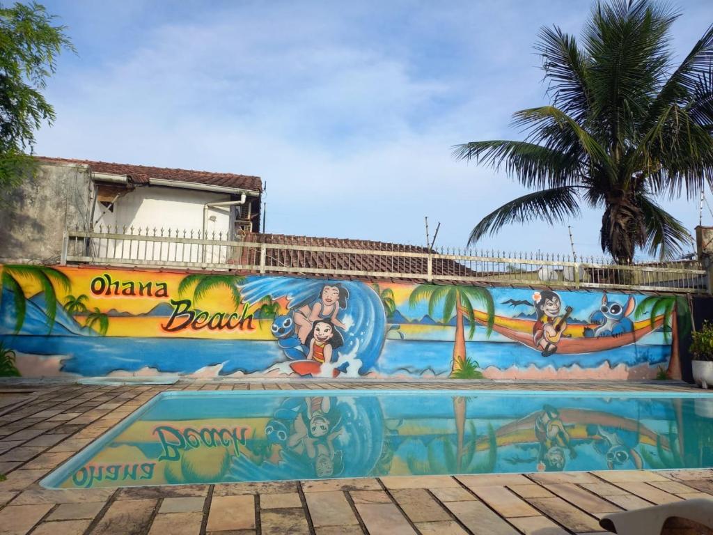 um mural na lateral de um edifício com piscina em Hostel Ohana Beach em Mongaguá