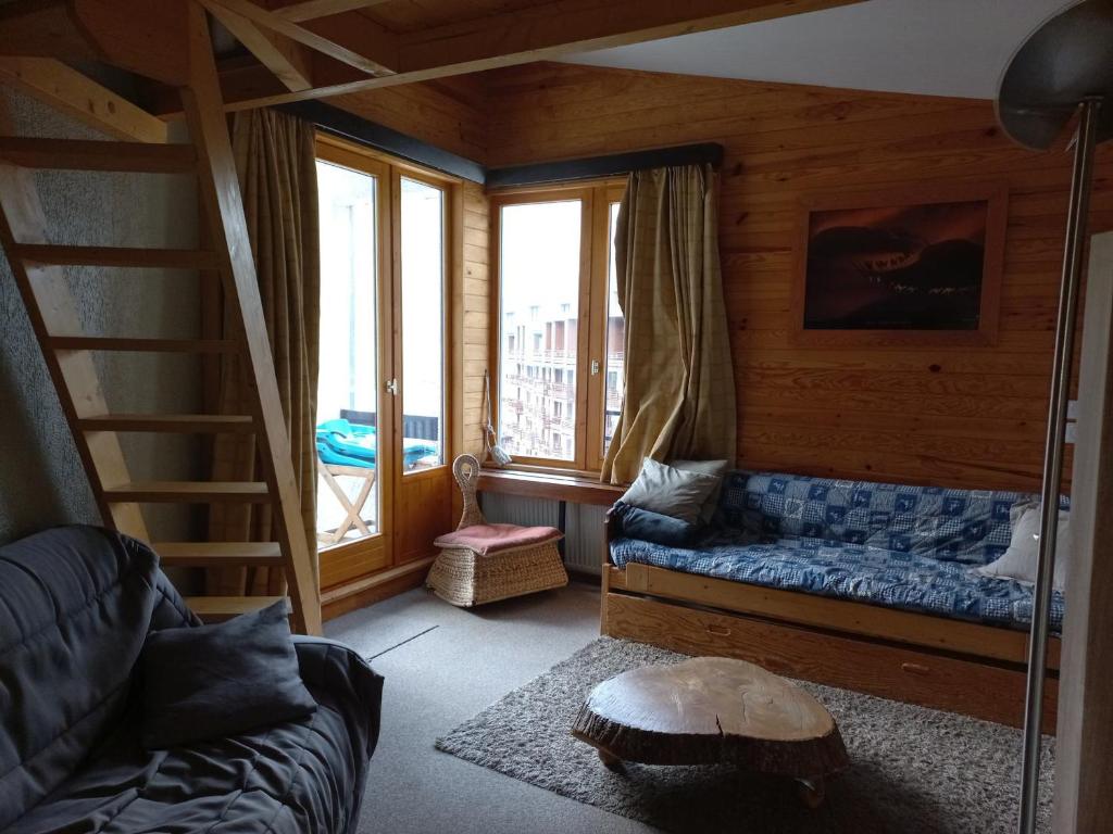 a living room with a blue couch and a staircase at Appartement Tignes, 2 pièces, 7 personnes - FR-1-449-65 in Tignes