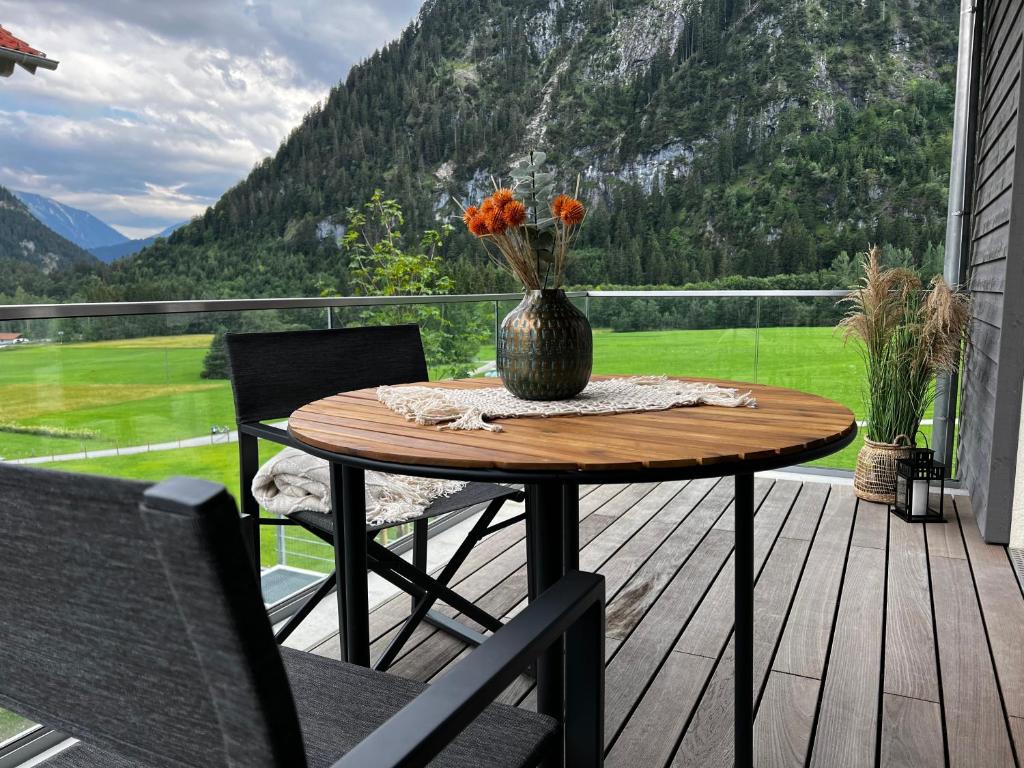 uma mesa sobre um convés com um vaso sobre ele em Appartement Louis em Oberammergau