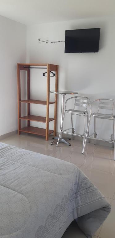 een kamer met een tafel en twee stoelen en een televisie bij Quinta do Lapa in Florianópolis