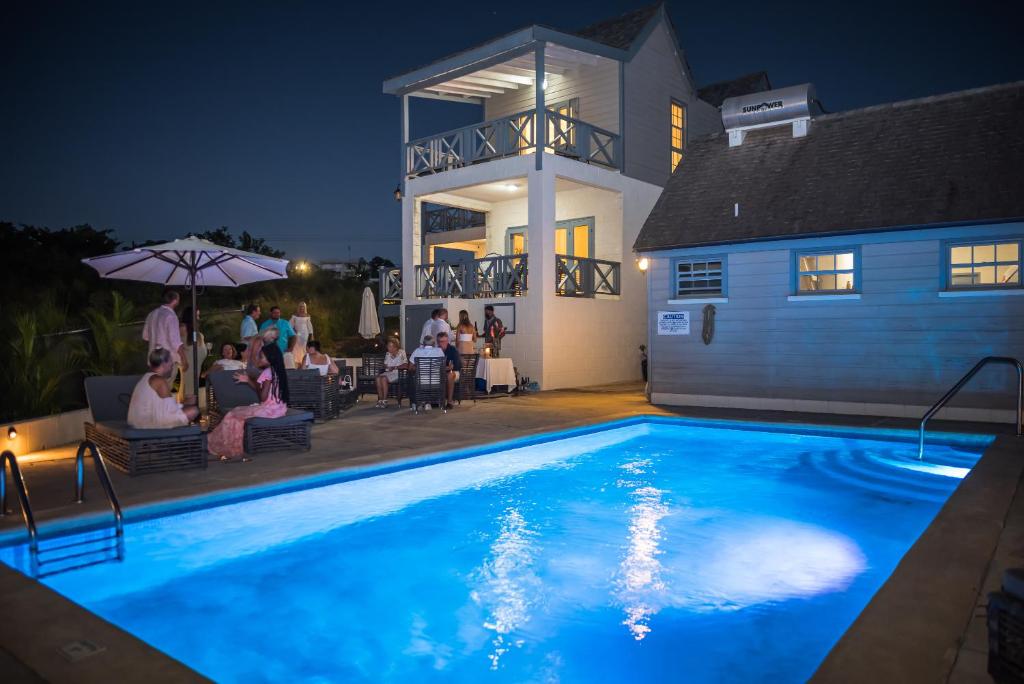 a swimming pool in front of a house at night at West Rock Villas in Saint James