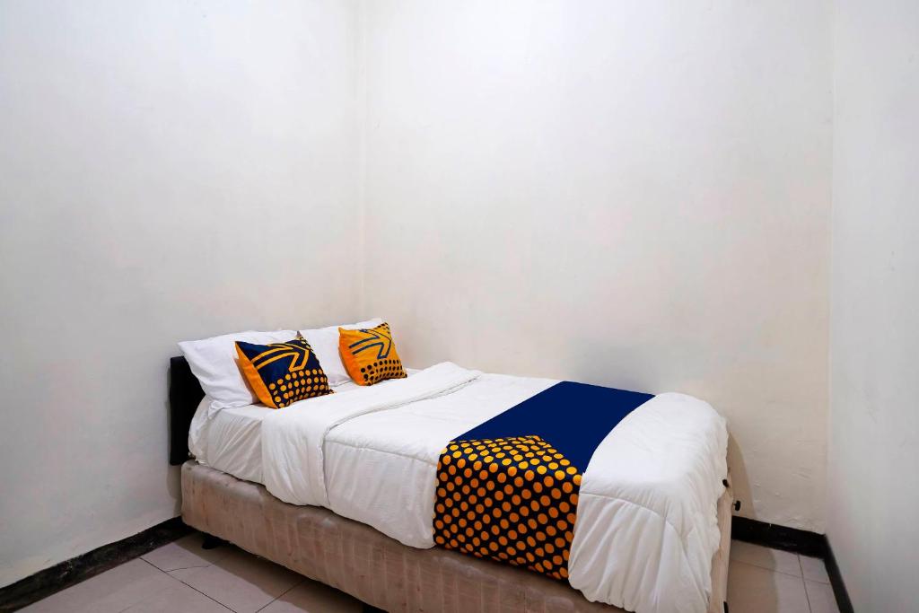 een bed met twee kussens in een kamer bij SPOT ON 91394 Pondok Paskal Syariah in Bandung