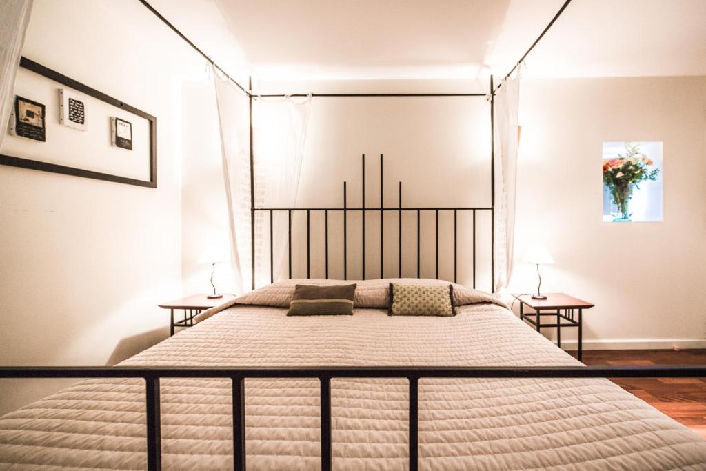 a bedroom with a bed with a metal headboard at Mas De Baumes in Ferrières-les-Verreries