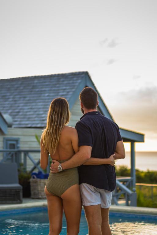 a man and a woman standing by a swimming pool at West Rock Villas in Saint James