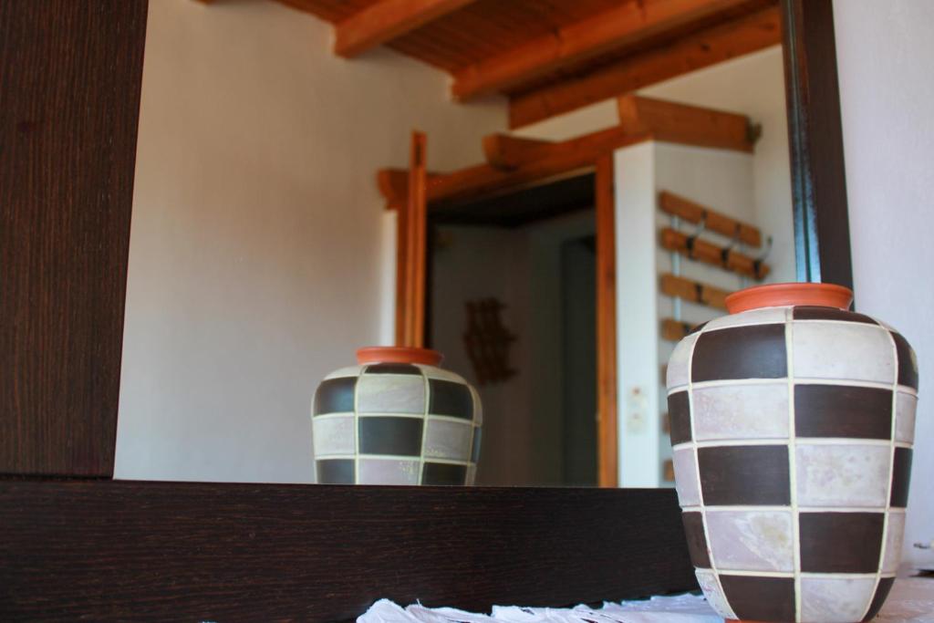 two vases sitting on a table in front of a mirror at Giovanni Group Apartments in Syvota