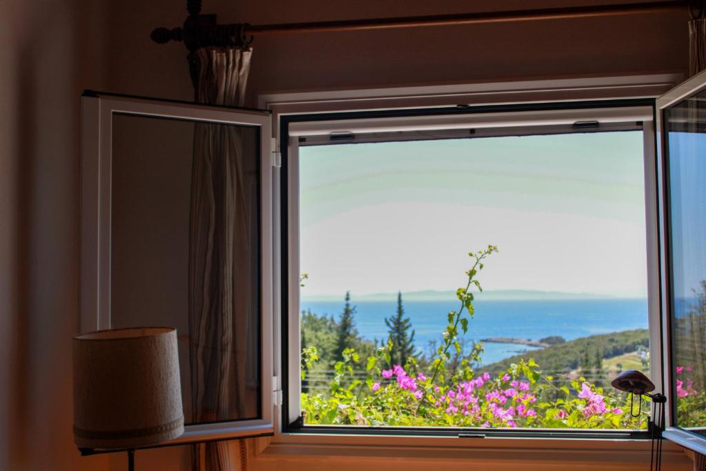 a window with a view of the ocean at Giovanni Group Apartments in Syvota