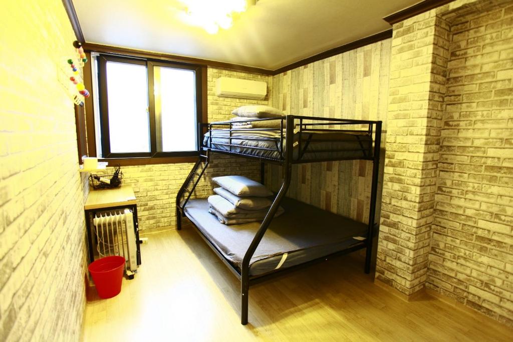 Zimmer mit Etagenbett in einer Ziegelwand in der Unterkunft Jungle guesthouse in Provinz Danyang-gun