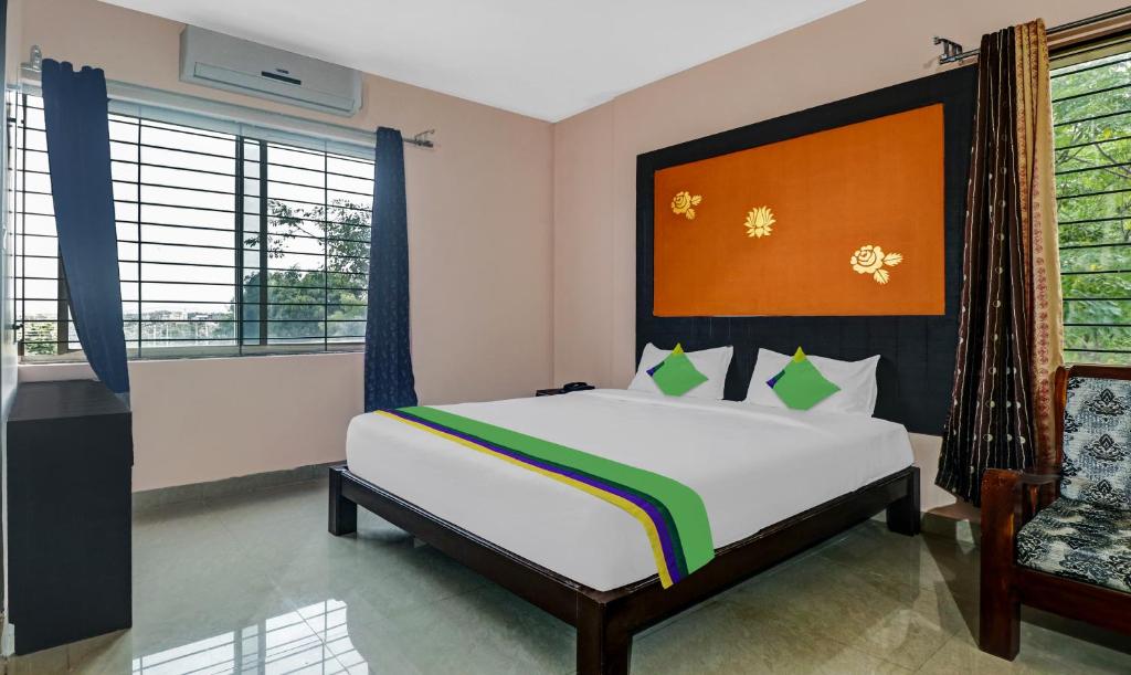 a bedroom with a bed and a chair at Treebo Trend Grand Jp Inn 3 Km From Gundlupet Bus Stand in Gundlupet