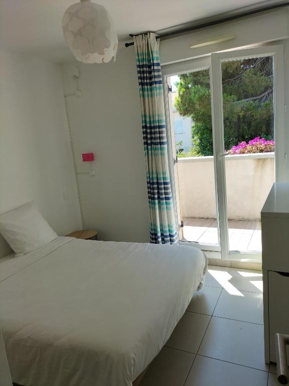 - une chambre avec un lit et une grande fenêtre dans l&#39;établissement Maison bijou plage, juan les Pins-Antibes, à Antibes