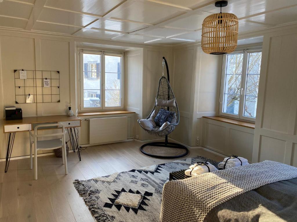 a room with a bed and a desk and windows at Ferienwohnung Blumerhaus in Mitlödi in Mitlödi