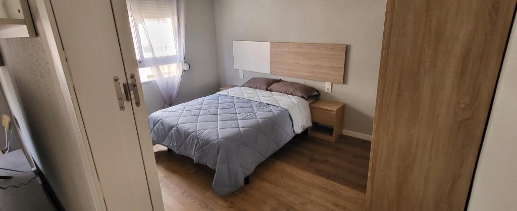 een kleine slaapkamer met een bed en een raam bij Tenerias 2 in Castellón de la Plana